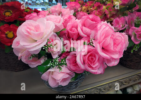 Roses roses artificielles close-up. Dans les paniers sont des bouquets de fleurs artificielles pour la vente. Fleurs artificielles pour l'intérieur. Banque D'Images