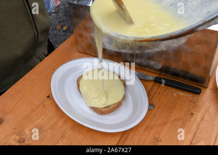 La préparation de fromage fondu traditionnel sur un pain sur les Alpes Suisses Banque D'Images