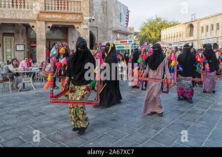 Doha, Qatar-January 4, 2019 : l'arabe traditionnel souk Waqif mesdames danser dans la lumière du jour voir Banque D'Images