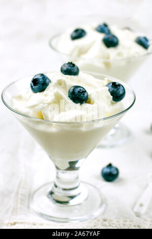Le régime alimentaire des yaourts avec de gros bleuets frais. En verre de yaourt non sucré blanc Banque D'Images