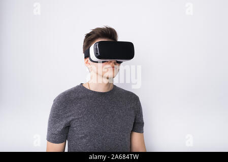 Jeune homme à lunettes viar. Un adolescent joue avec des lunettes de réalité virtuelle. Banque D'Images