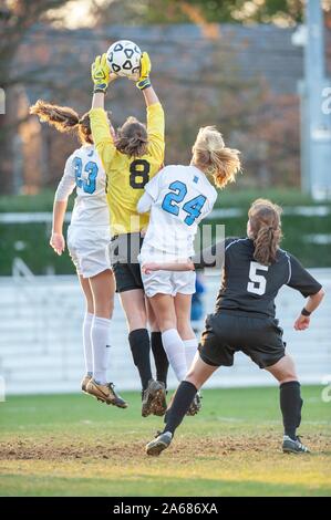 Tourné sur toute la longueur de deux Johns Hopkins University Women's Soccer players, saut en tandem avec un gardien adverse qui atteint pour la balle, au cours d'une demi-finale de conférence du centenaire avec match Haverford College, le 7 novembre 2009. À partir de la collection photographique de Homewood. () Banque D'Images