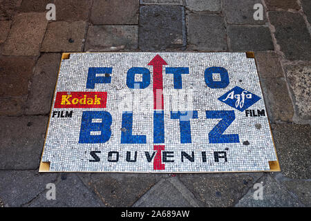 Une mosaïque signe sur le terrain pour les résidents et touristes de pointage Foto Blitz, un appareil photo, film & digital imaging store sur Calle dei Baloni à Venise, Italie Banque D'Images