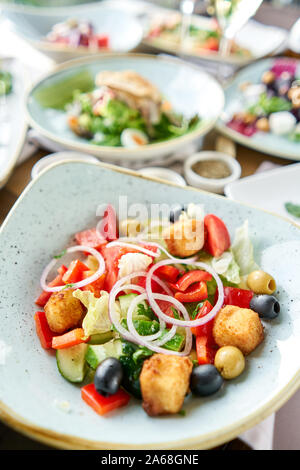 Salade grecque traditionnelle avec des légumes frais, fromage feta et olives. Variété de plats sur la table. Divers en-cas et antipasti sur la table Banque D'Images