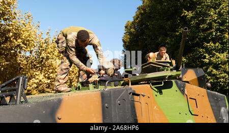 Strasbourg, France - Sep 21, 2019 : Les soldats aider kid à mettre sur le casque militaire blindé français dans le centre de place Broglie pendant les journées portes ouvertes de l'armée française Banque D'Images