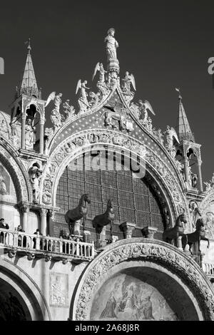 Détail de la façade ouest de la basilique San Marco, montrant les chevaux caracolant et autres détails ornementaux : San Marco, Venise, Italie. Version noir et blanc Banque D'Images