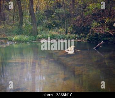 L'eau claire sans une seule feuille à l'automne sur une rivière. Formation rocheuse culminant visible hors de l'eau. Arbre mort ci-dessus de l'eau. Un calme Banque D'Images