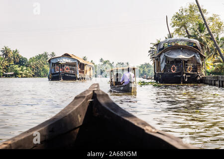 Alleppey - Alappuzha, Inde - 13 novembre 2017 : Les petits bateaux qui passent le long de bateaux sur le fleuve du Kerala backwaters avec palmiers tropicaux Banque D'Images