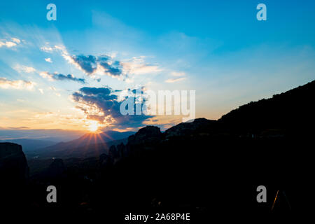 Les Météores silhouetting coucher de soleil sur les affleurements rocheux et les collines Banque D'Images