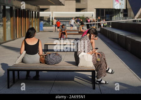 Montréal, Québec / Canada - le 24 juillet 2019 : plusieurs personnes regardent sur leur téléphone alors qu'une femme seule recherche Banque D'Images