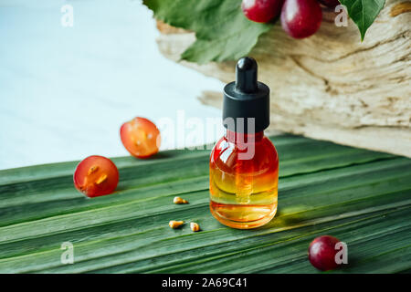 L'huile de pépins de raisin. Still Life de bouteille avec de l'huile de pépins de raisin, et sur l'arrière-plan naturel Banque D'Images