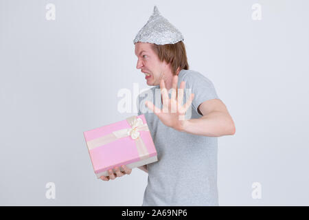 Jeune homme a souligné avec tin foil hat holding gift box et à la peur Banque D'Images