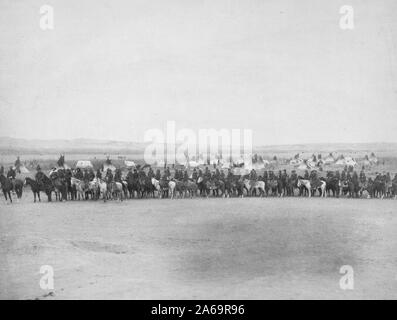 Longue rangée de militaires, hommes et Lakota scouts à cheval en face de camp tipi--probablement sur ou près de la réserve de Pine Ridge. Banque D'Images