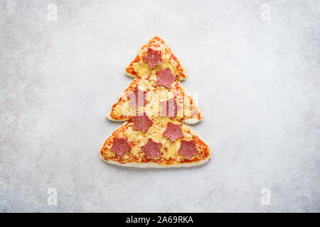 Pizza en forme de sapin de Noël décoré avec des étoiles faites de pepperoni. Livraison de pizza la publicité. Noël fête snack-idée. Banque D'Images