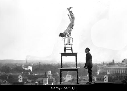 J. Reynolds, Acrobat performing acrobatique et numéros d'équilibre au-dessus du bâtiment au-dessus de la 9e rue NW à Washington D.C. ca. 1917 Banque D'Images