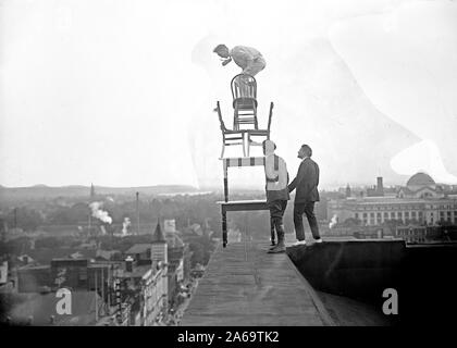 J. Reynolds, Acrobat performing acrobatique et numéros d'équilibre au-dessus du bâtiment au-dessus de la 9e rue NW à Washington D.C. ca. 1917 Banque D'Images