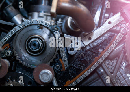 Gros plan sur un moteur démonté avec une vue sur le mécanisme de distribution du gaz ; chaîne ; engrenages et des galets pour la réparation et la restauration après un bre Banque D'Images