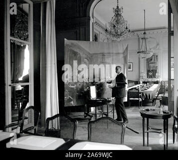 M. Herbert A. Oliver, peintre anglais, au travail sur une toile de la réunion des délégués de paix des alliés. Versailles, France ca. Mars 1919 Banque D'Images