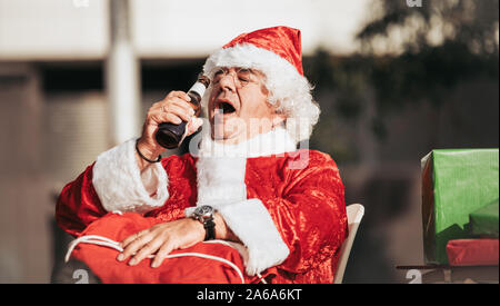 Stock photo de profil du père noël sans barbe de boire une bière. Temps de Noël Banque D'Images