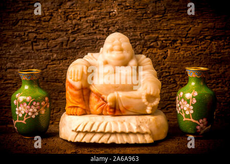 Figurine spirituelle Budai Maitreya entre vert foncé sur vases ornementaux du plateau au sol Banque D'Images