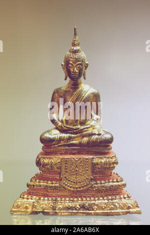 Statue de Bouddha en laiton assis dans une posture de méditation sur un piédestal Banque D'Images