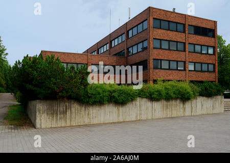 Bâtiment en brique sombre office et en béton massif avec des plantes Banque D'Images