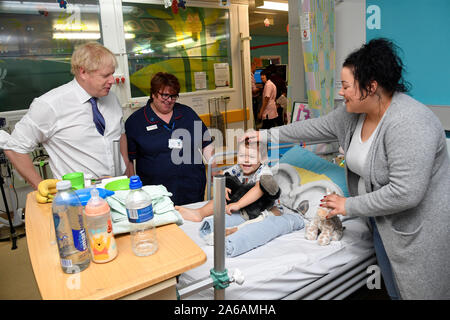 Premier ministre Boris Johnson se réunit quatre ans George patient et sa mère Kelly, Aspenwall à la salle commune des enfants qu'il visite l'Hôpital Universitaire de Milton Keynes Buckinghamshire. Banque D'Images