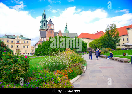 Les touristes à pied par un chemin le long de la fleur principale avec jardin courrtyard avec le Château Royal de Wawel et la cathédrale du Wawel en arrière-plan, le centre de Cracovie, Po Banque D'Images