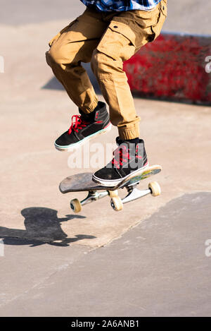 Un petit garçon avec le TDAH, l'Autisme, syndrome d'Aspergers pratique de sa planche à roulettes à l'échelle locale skate park, énergiques et enthousiastes, le patinage Banque D'Images