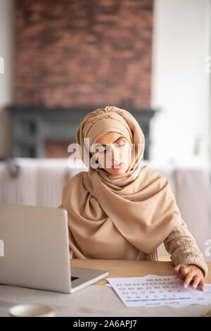 Belle jeune fille faisant un travail assis près de l'ordinateur portable Banque D'Images