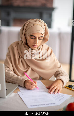 Pretty woman wearing hijab s'occupent des fonctions Banque D'Images