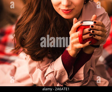 Sourire d'une femme à l'automne parc avec tasse de café dans les mains. Banque D'Images