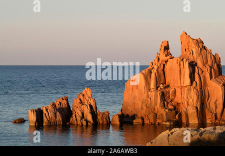 Les touristes appréciant les Rocce rosse / Roches Rouges de porphyre, Arbatax Plage côte Ogliastra dans Tortolì, Sardaigne, en Italie Banque D'Images