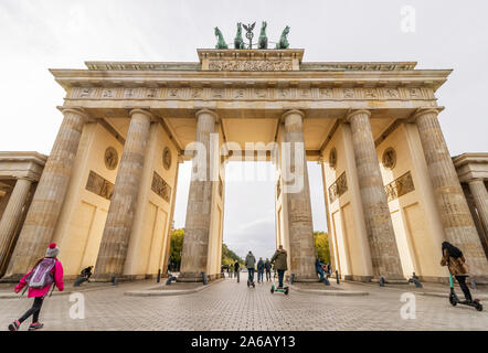 Trafic de personnes à pied ou en scooter électrique sous le soleil, Porte de Brandebourg, Berlin, Allemagne Banque D'Images