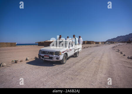 4 personnes assis à l'arrière d'un pick up truck dans cette magnifique plage autour de Dahab dans le sud du Sinaï. Banque D'Images