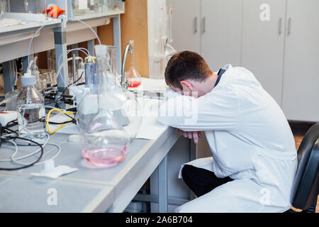 Scientifique dans le laboratoire médical dort dans le lieu de travail Banque D'Images