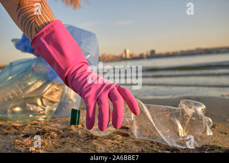 L'étudiant responsable de pourpre des gants de caoutchouc est la marche avec sac à déchets le long d'une rive de la rivière sale et le nettoyage de la corbeille, bouteille en plastique. Les gens Banque D'Images