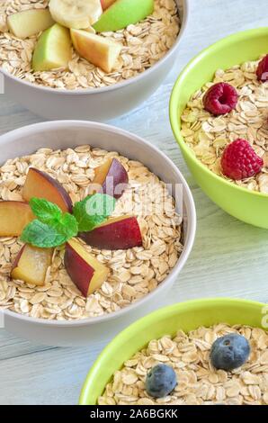 Délicieux doux petit déjeuner sain. Porridge avec différents fruits sur une table de cuisine en bois. Banque D'Images