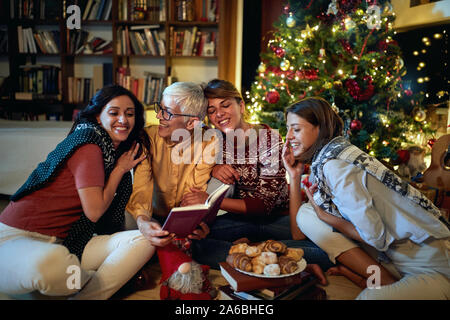 Cheerful mather et sa fille heureux ensemble pour Noël en face d'un arbre décoré x-mas Banque D'Images