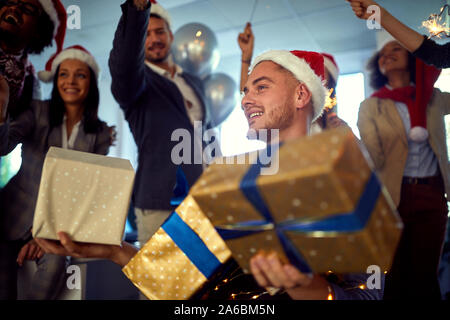 Groupe de professionnels des employés de bureau célébration de Noël.Young smiling man in santa hat à Noël. Banque D'Images