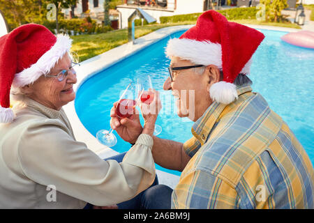 Happy senior couple with Santa hats célébrer Noël. Banque D'Images