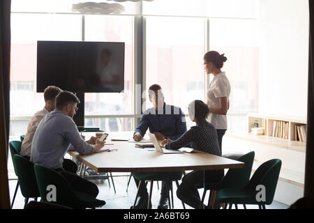 Les jeunes concentrés à l'écoute de l'équipe diversifiée entraîneur féminin Banque D'Images