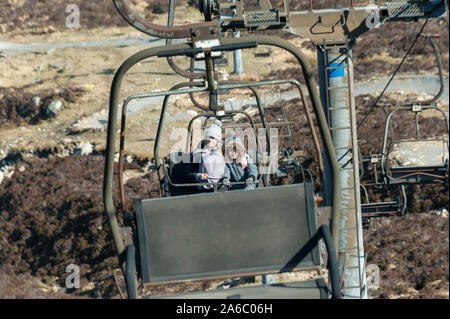 Deux personnes à l'aide d'un télésiège dans une station de ski Banque D'Images