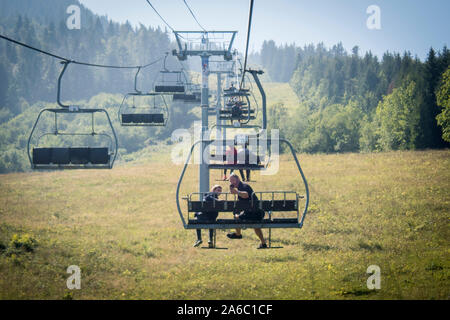 Deux personnes à l'aide d'un télésiège dans une station de ski Banque D'Images