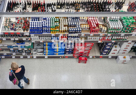 Regardant vers le bas sur l'allée des boissons au supermarché Sainsbury's, à Gloucester avec une femme le choix de bières qui à acheter Banque D'Images