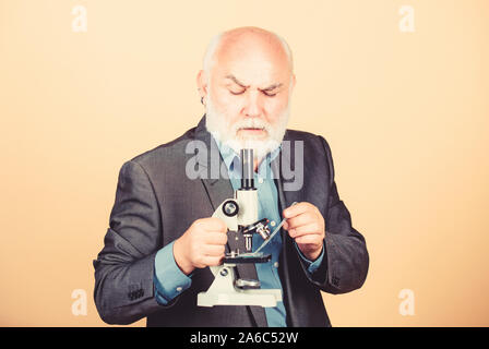 Homme mature costume formel avec microscope. Travail de doctorat et postdoctoral de l'emploi. Projets doctorat de biologie moléculaire. Professeur expérimenté de la biologie. Le professeur chargée de cours à l'université. Expert scientifique en microbiologie. Banque D'Images