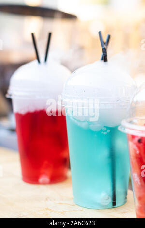 Boisson aux fruits multicolores avec vapeur sortant. Cocktail sans alcool. La verticale. Close up. Banque D'Images