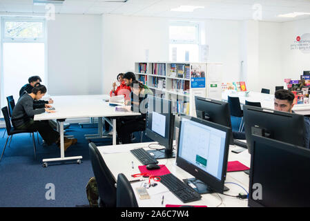 Outre-mer international étudiants assis dans une bibliothèque universitaire la lecture de livres Banque D'Images