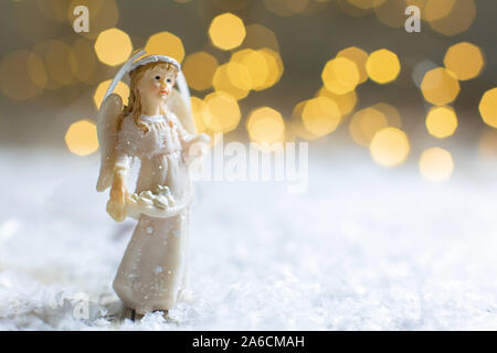 Sur le thème de Noël Décoration figurines. Statuette de un ange de Noël. Décoration d'arbre de Noël. Décor de fête, chaud bokeh lights Banque D'Images