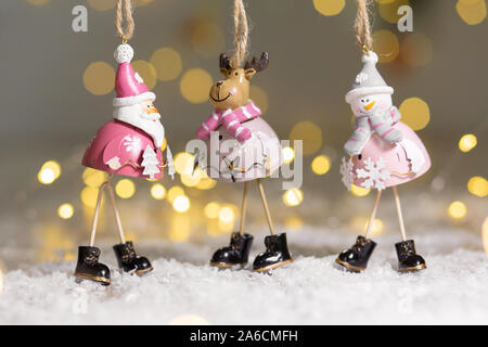 Figurines décoratives d'un thème de Noël. Ensemble de statuettes de santa, bonhomme de neige et les cerfs. Décoration d'arbre de Noël. Décor de fête, chaud bokeh lights Banque D'Images